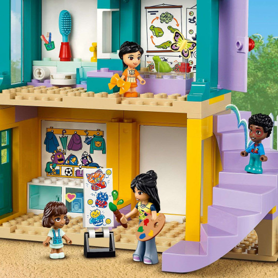 LEGO Friends Školka v městečku Heartlake s minipanenkami, herními prvky a doplňky pro péči o nejmenší obyvatele školky. Dvě minipanenky si hrají s dětmi v herní místnosti plné hraček, s prolézačkou a dětskými potřebami.