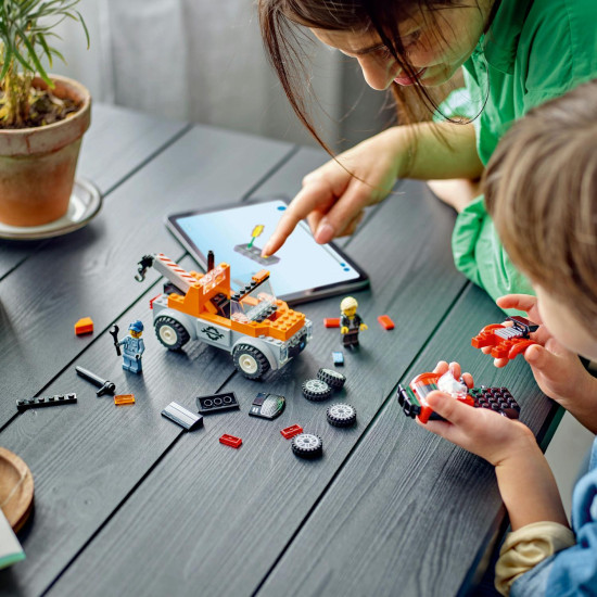 Odtahový vůz LEGO® s řidičem v pohodlné kabině, odolnými širokými pneumatikami a funkčním navijákem, který odtahuje zkažený sporťák, připravený na pomoc v každé situaci.