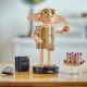 LEGO figurka Dobbyho stojí na podstavci se jmenovkou, drží Harryho ponožku v deníku Toma Riddla a vedle něj levituje pudinkový koláč tety Petunie.