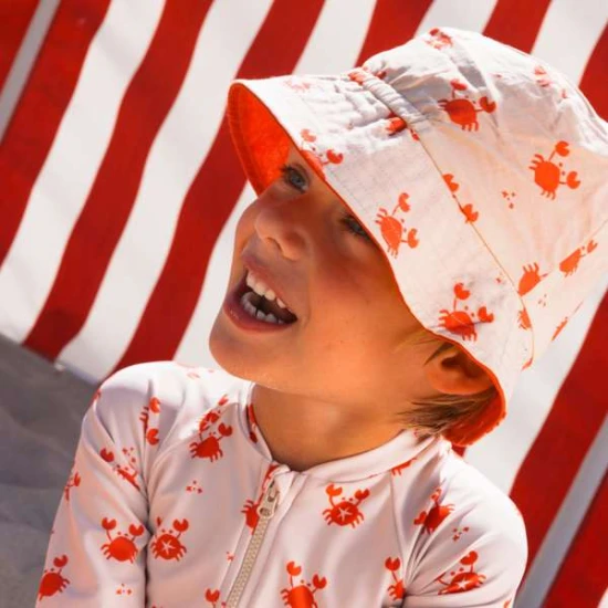 Oboustranný klobouček pro děti s UPF 50+ – krabí vzor na jedné straně, jednobarevný design na druhé. Široký okraj pro ochranu před sluncem.