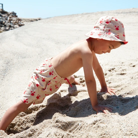 Oboustranný klobouček pro děti s UPF 50+ – krabí vzor na jedné straně, jednobarevný design na druhé. Široký okraj pro ochranu před sluncem.