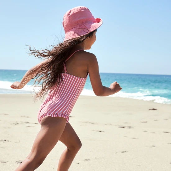 Oboustranný klobouček pro děti s UPF 50+ – květinový vzor na jedné straně, jednobarevný design na druhé. Široký okraj pro ochranu před sluncem.