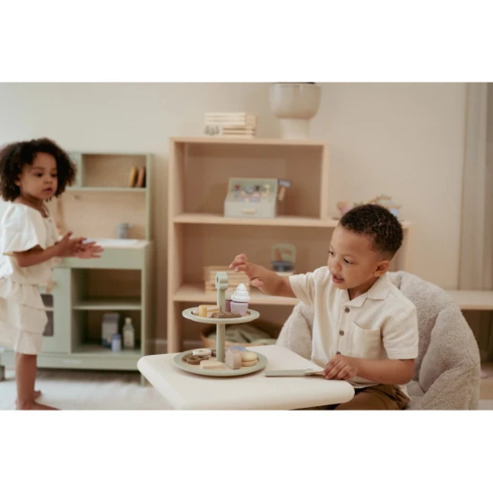 Dvouposchoďový dřevěný stojan na pečivo Little Dutch s různými sladkými zákusky a obrázkovým menu.